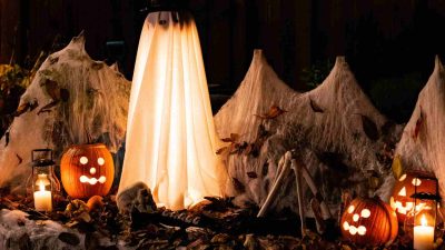 Visitors walking through fog-filled scare zones and haunted house entrances at Universal Orlando’s Halloween Horror Nights 2025, surrounded by eerie lighting and live performers.
